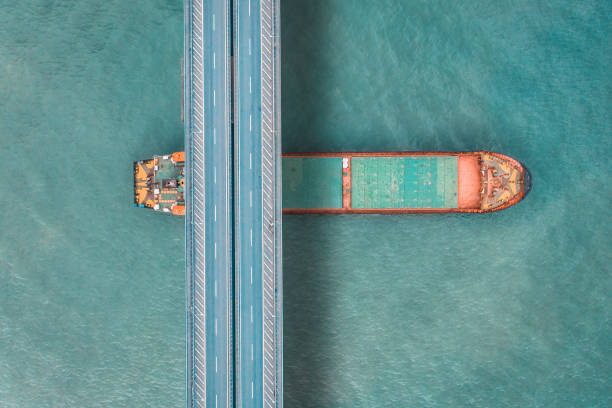 istock Aerial view of a cargo ship passing under bridge. 1395966864