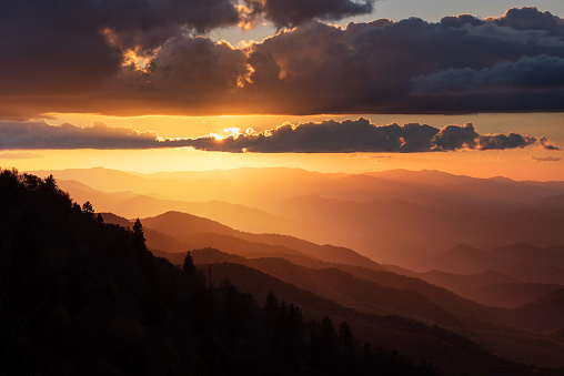 Sunset light spilling out across the Smoky Mountains and highlighting the layers of ridges from along the Blue Ridge Parkway