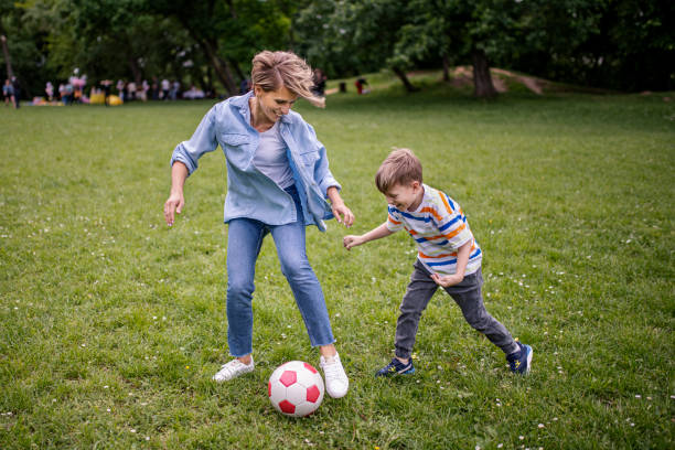 istock Smiling mother with happy son playing with a ball 1395974494