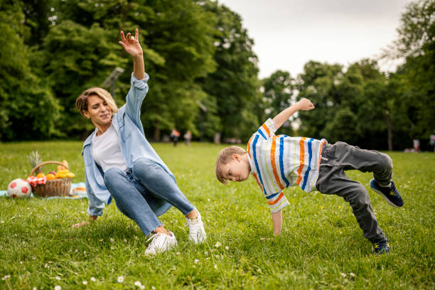Mother and son learning to dance breakdance in the park stock photo