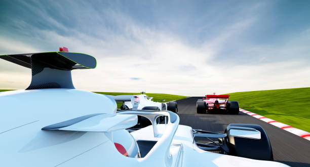 Low level, close up image of a  generic racing car moving at high speed around a bend in a racetrack under a blue sky with light cloud.