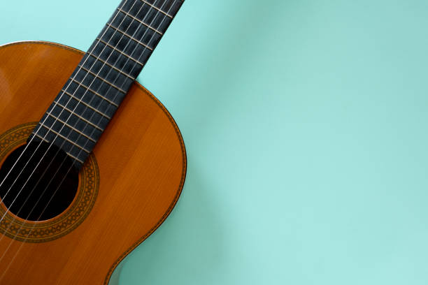 istock old classic guitar on green table background, music concept 1395993250