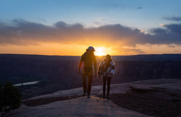 Young couple with with backpack hiking  in Moab park, Utah