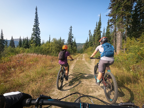 Personal perspective of a father following wife and daughter on mountain bikes.  Sun Peaks, British Columbia, Canada.