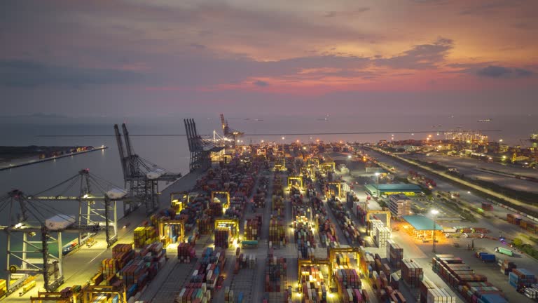 Day to night Hyperlapse time-lapse of Business Logistics and transportation of Container Cargo ship with working crane bridge in shipyard at night of working late.Matching day & night city skylines  concept.(with alpha chanel)