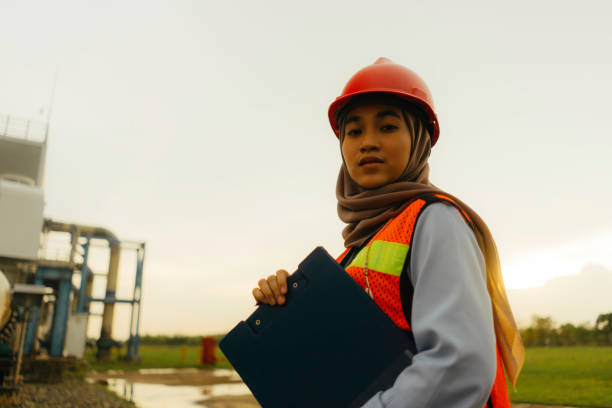 공장 건물에서 일하는 젊은 아름다운 엔지니어 여성의 초상화 - site natural gas 뉴스 사진 이미지