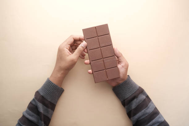 istock top view of holding dark chocolate on orange background 1396013829