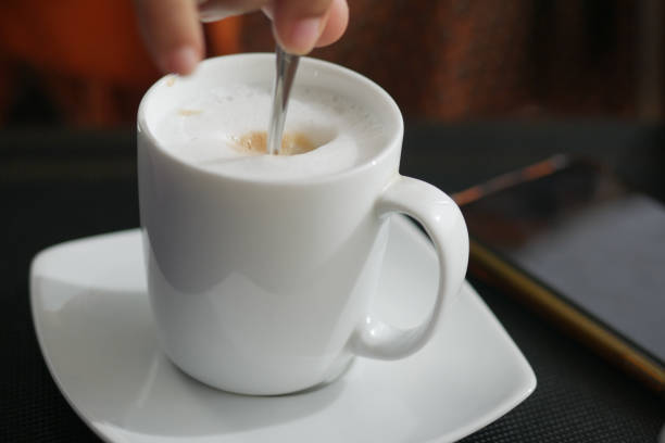 istock person hand stirring coffee with spoon. 1396013842