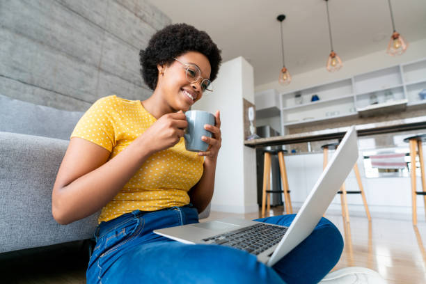 istock Happy woman working at home on her laptop while drinking coffee 1396019818