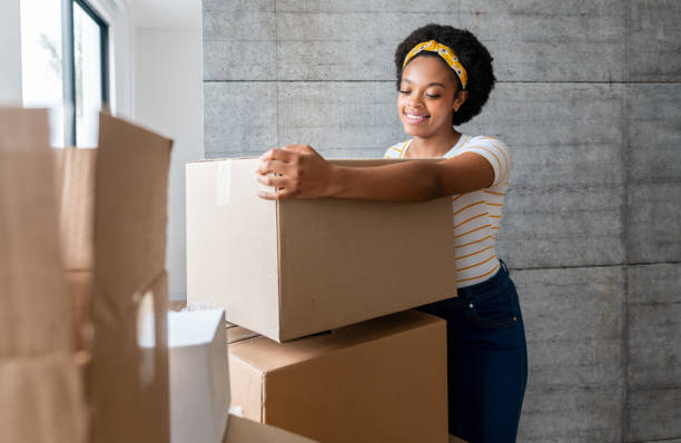 istock Happy woman moving house and packing in boxes 1396019834
