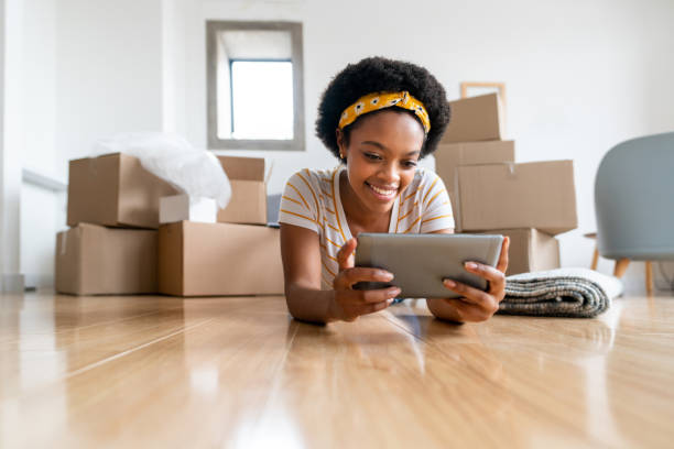 istock Woman moving house and using a tablet while taking a break from packing 1396019856