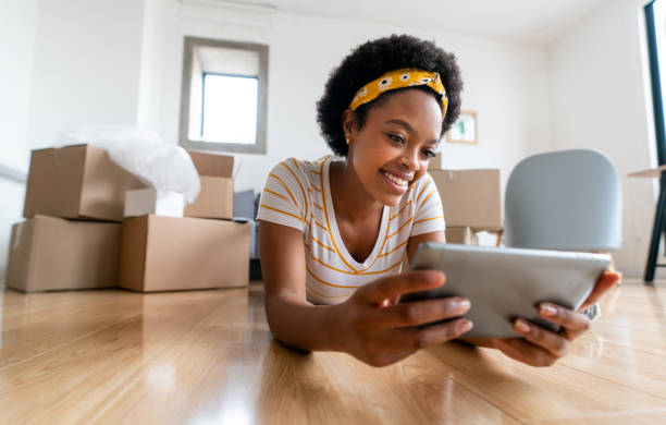 istock Woman watching videos on a tablet while taking a break from packing 1396019857