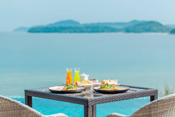 신선한 과일, 차, 바다와 푸른 언덕이있는 패스트리가있는 열대 식 아침 식사 - honeymoon color image horizontal setting the table 뉴스 사진 이미지