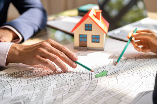 istock Human Hand Holding Pencil Over Cadastre Map 1396023717