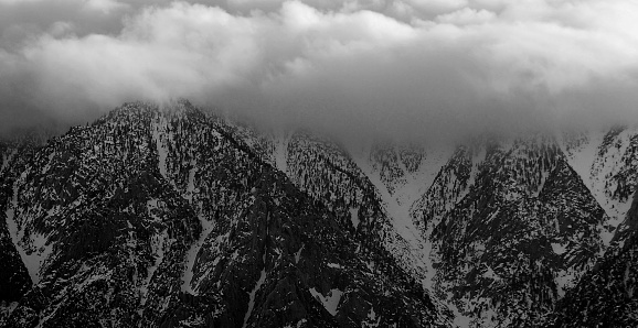 San Jacinto mountains with snow and under cloud cover.   Black and white.
