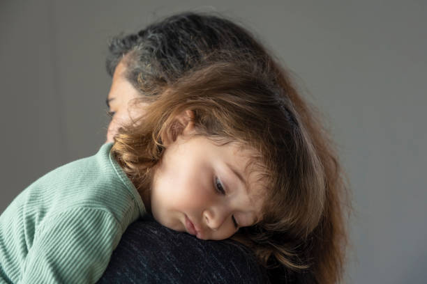 istock toddler leaning on his mother's lap 1396028025