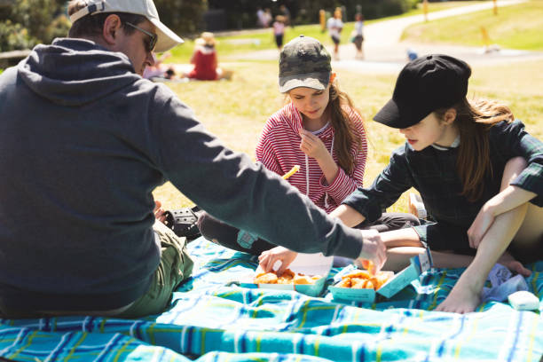 istock Father and two daughters at the picnic on a sunny day 1396029696