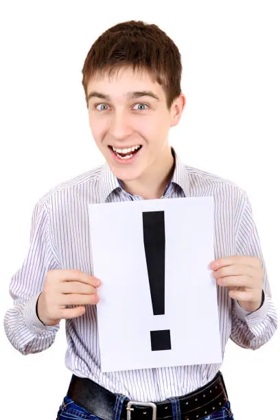 Cheerful Teenager holds a sheet with Exclamation Mark Isolated on the White Background