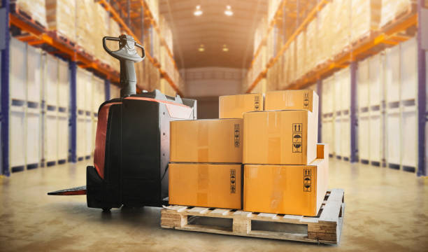 istock Electric Forklift Pallet Jack with Packaging Boxes on Pallet in Storage Warehouse. Cargo Shipping.  Warehouse Inventory Management. Tall Shelf Storage. Supplies Warehouse. Shipment Boxes. 1396036870