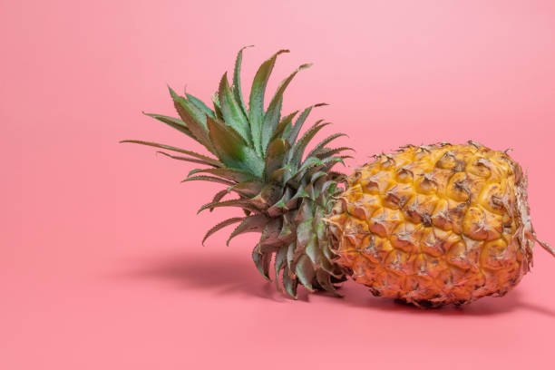 istock Minimal healthy food fruit pineapple on pink table. 1396042163