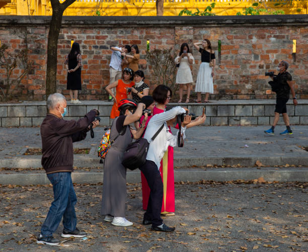 Hanoi, Vietnam - March 26, 2022: a group of photographers on a street near the Imperial citadel