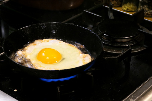 Bavaria, Germany.  Fried egg on the gas cooker in the pan. The egg is from a real Bavarian rooster and one of its hens as part of a simple Bavarian peasant meal.