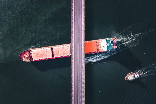 istock Aerial view of a cargo ship passing under bridge. 1396043474