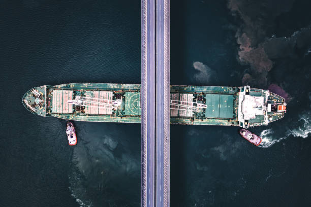 istock Aerial view of a cargo ship passing under bridge. 1396043483