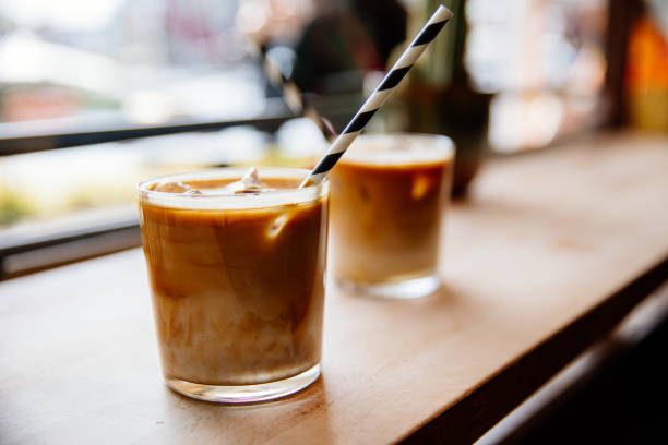 Two iced latte on wooden table Two iced latte on wooden table iced coffee stock pictures, royalty-free photos & images