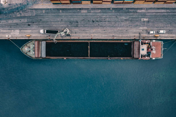 rozładunek węgla przez statek towarowy w porcie handlowym. - coal crane transportation cargo container zdjęcia i obrazy z banku zdjęć