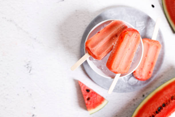 istock Watermelon ice cream pops in white bowl with ice on marble table background. 1396048630
