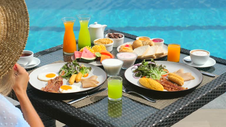 Woman on breakfast in hotel resort in sunny day. Morning food on villa