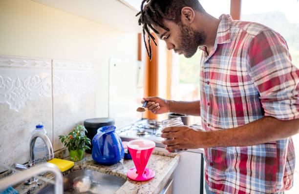 istock Young man making a fresh coffee at his kitchen counter 1396053033