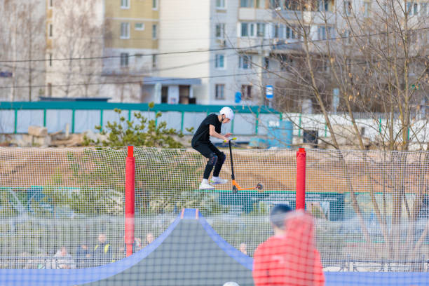 un jeune homme conduit un scooter de cascade sur une rampe de skatepark. russie, zelenograd, 23 avril 2022 - sports clothing kicking high up tall photos et images de collection