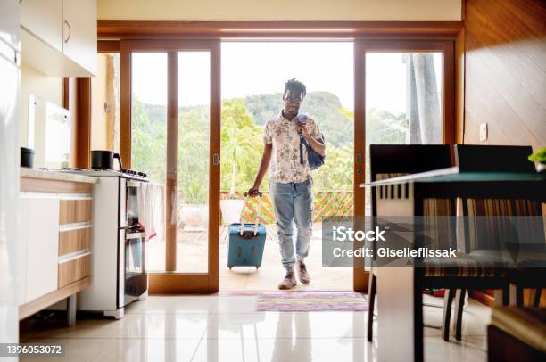 Man With A Suitcase Walking Through The Patio Doors Of His Accommodation Stock Photo - Download Image Now