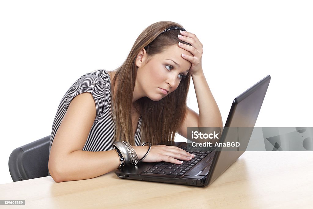 Stressed out girl Young beautiful woman having trouble with her computer, isolated on white. 16-17 Years Stock Photo