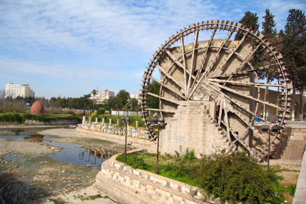 Wooden water wheel spinning vigorously in a rustic natural setting
