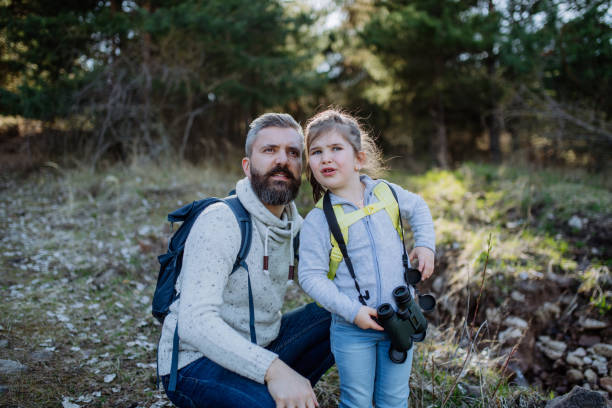 istock Father with small daughter with binoculars on walk in spring nature together. 1396056799