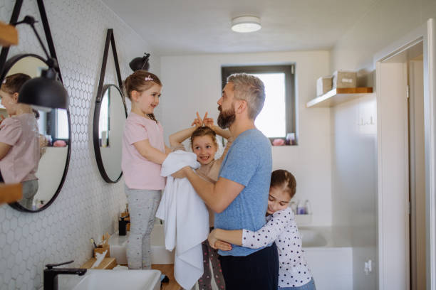 istock Father bonding with his three little daughters in bathroom, morning routine concept. 1396057670