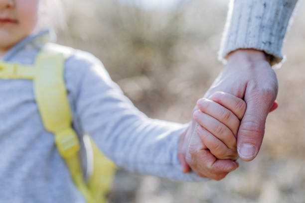 istock Father and daughter hold hands on walk in nature. 1396057684
