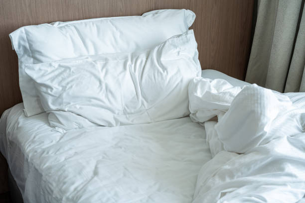 istock Messy  unmade bed with white linens and pillow 1396058136