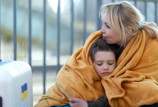 immigrati ucraini depressi seduti e in attesa alla stazione ferroviaria. - relief foto e immagini stock