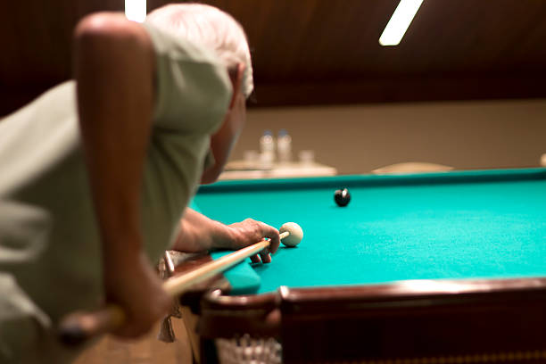 Senior man playing snooker at a bar