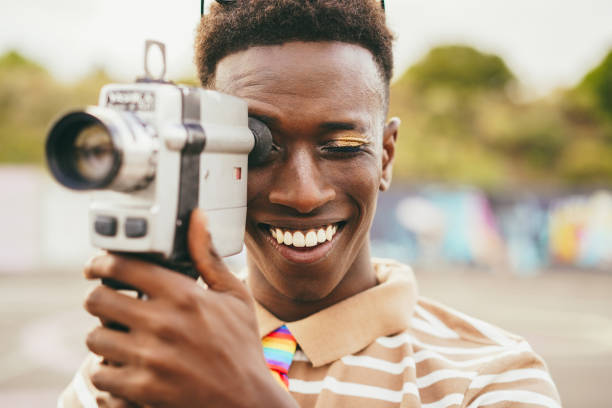 istock Young african man using vintage old video camera outdoor 1396063509