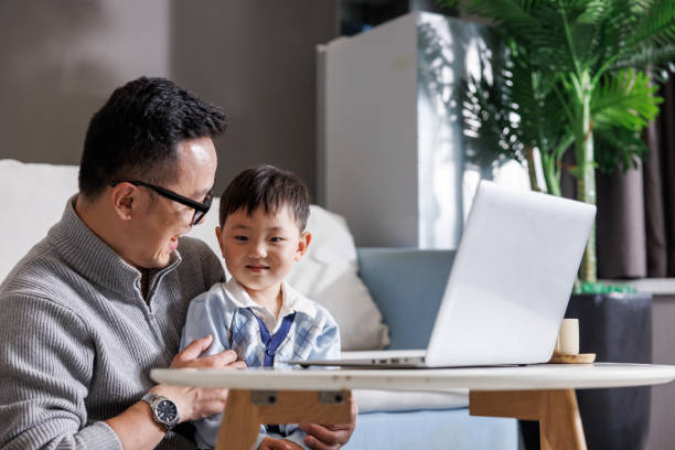 istock Father holding son working on laptop 1396063855