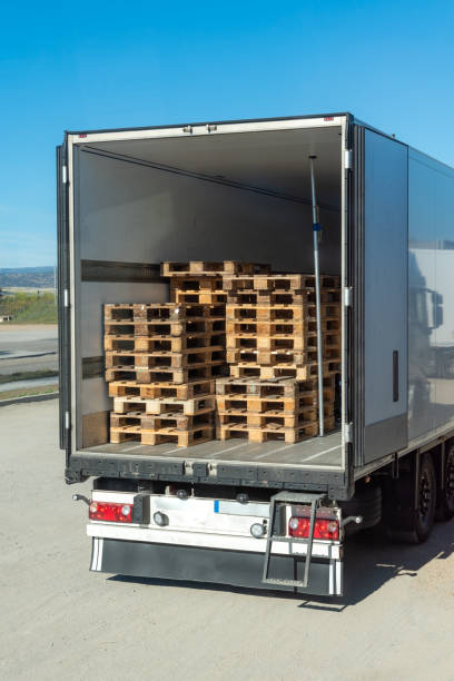 Refrigerated semi-trailer with open doors and empty Euro pallets inside, to exchange for those used in loading.