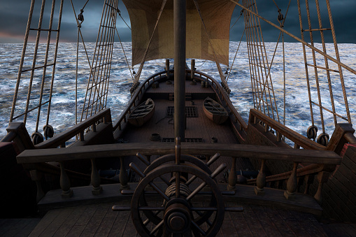 View of the deck from behind the ships wheel on an old pirate sailing ship in open sea with grey clouds. 3D rendering.