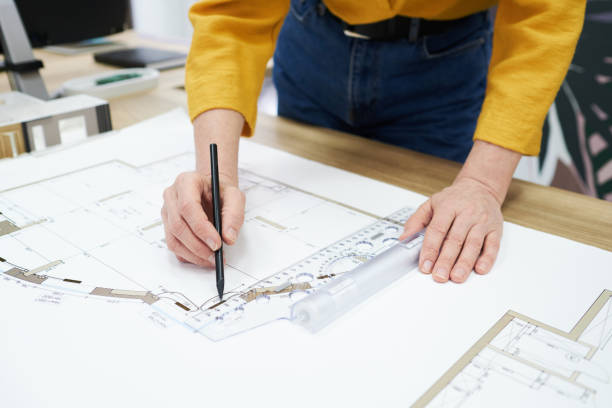 istock Woman working on construction plan at desk 1396069772