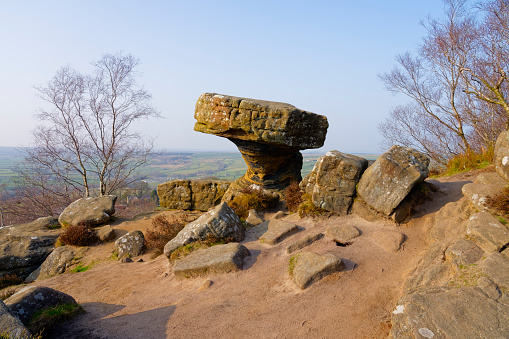 Eroded gritstone rock called the Druids Desk on a misty day in North Yorkshire
