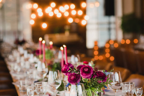 istock Table setting at the wedding reception. Floral compositions with beautiful ranunculus flowers and greenery, candles, laying and plates on decorated table. 1396071820